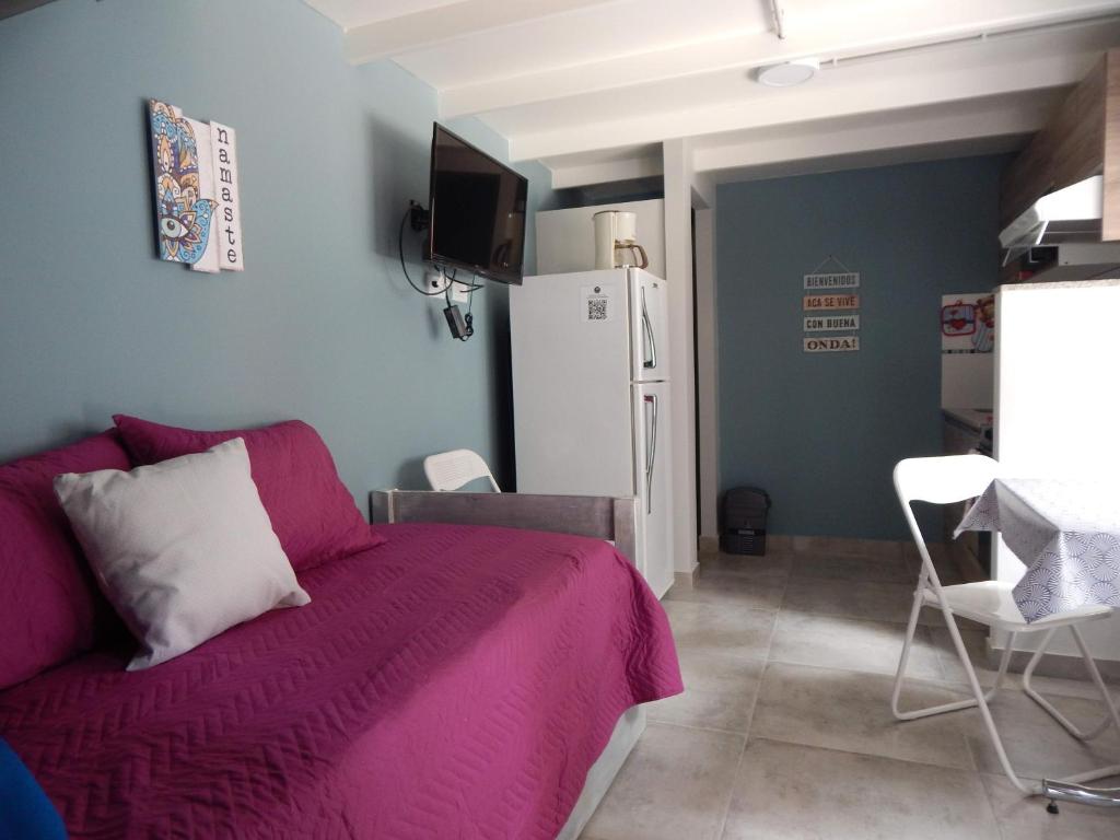 a bedroom with a purple bed and a refrigerator at Andanzas Bahia Uni in Bahía Blanca