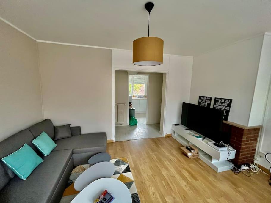 un salon avec un canapé et une télévision à écran plat dans l'établissement Le boréal, à Amiens