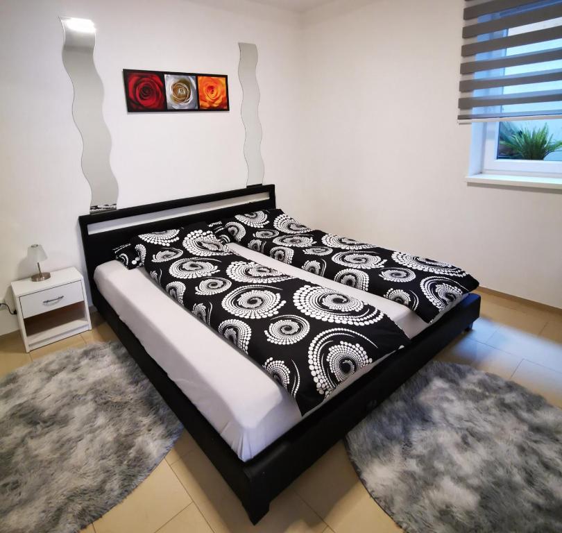 a bed with a black and white comforter in a bedroom at Neue Ferienwohnung in Ansbach