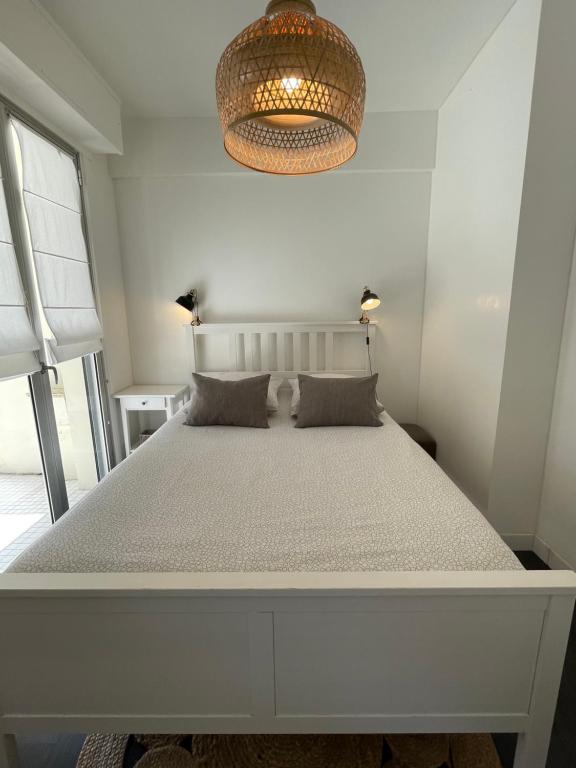 a white bedroom with a large bed with two pillows at Appart Grande terrasse in Saint-Jean-de-Luz