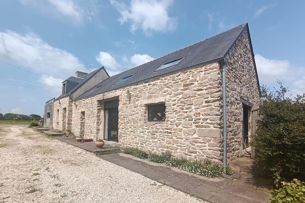 a stone building with a black roof at Gite L'escale in Pouldreuzic