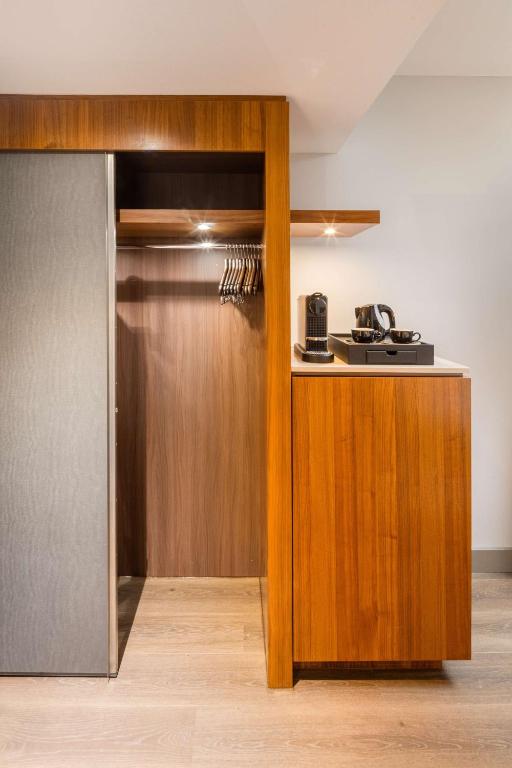 a kitchen with a wooden cabinet and a refrigerator at Radisson Blu Hotel, Hamburg Airport in Hamburg