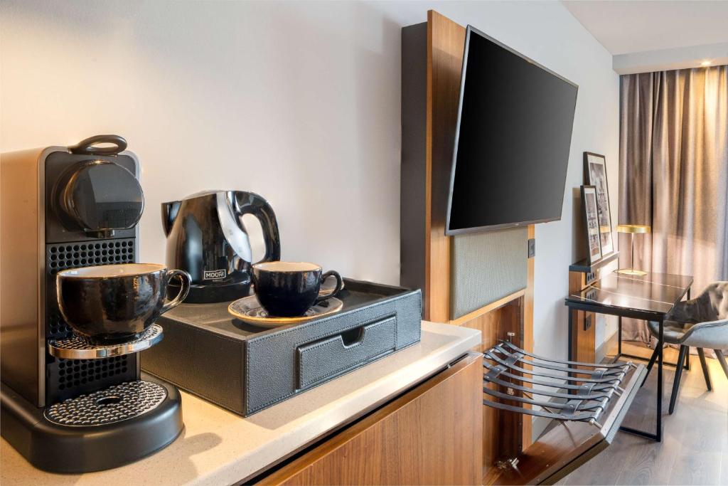 a hotel room with a coffee maker and a television at Radisson Blu Hotel, Hamburg Airport in Hamburg