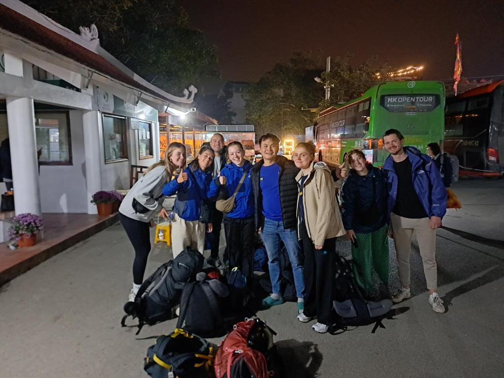 a group of people posing for a picture in front of a bus at Tam Coc Paradise Homestay in Ninh Binh
