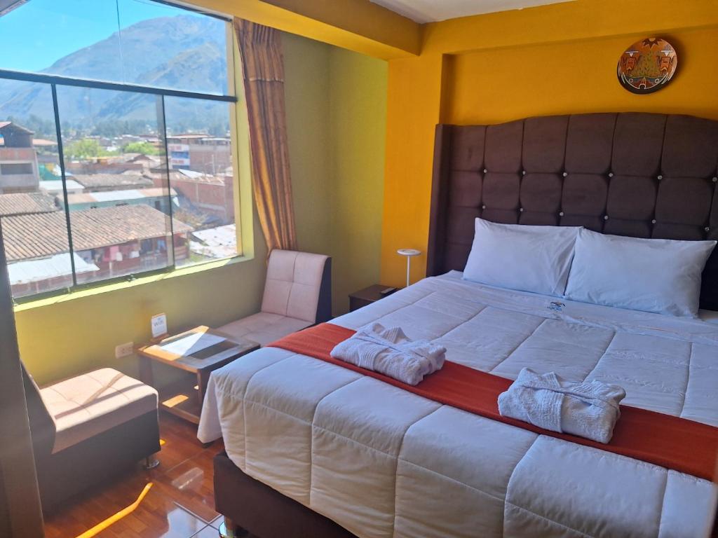 Un dormitorio con una cama grande y una ventana grande. en Chaska valle Inn, en Urubamba