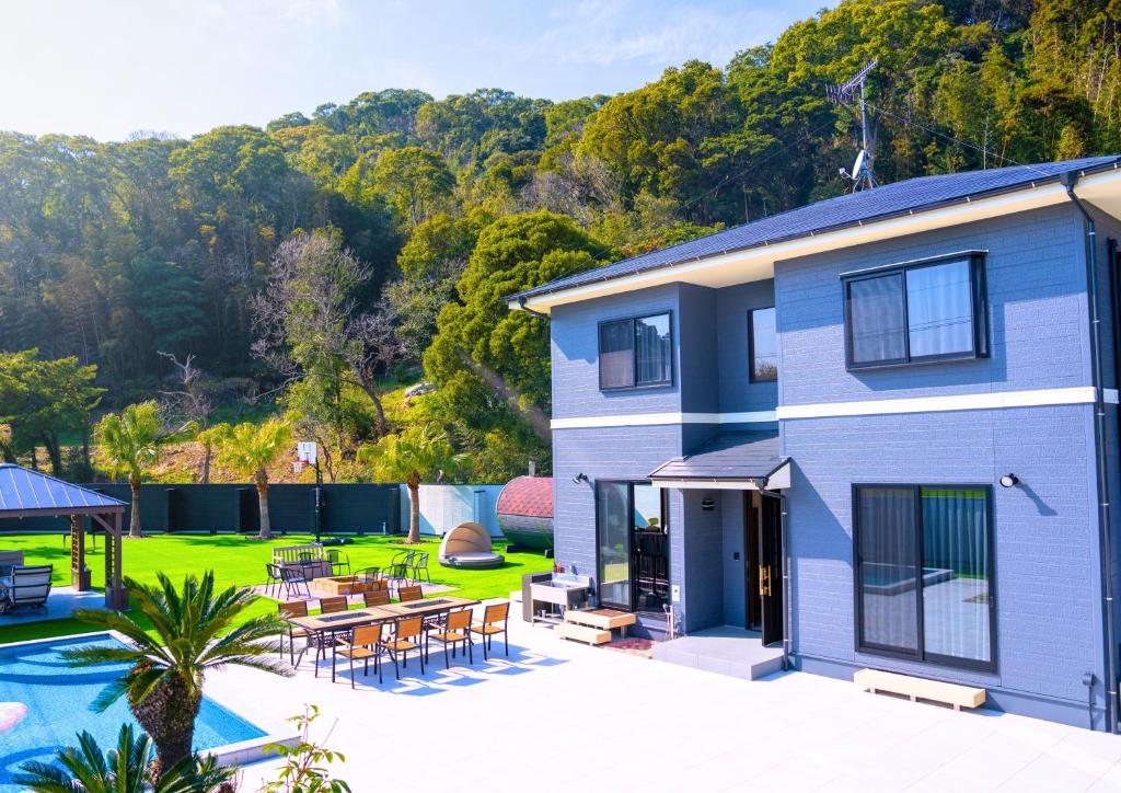 a blue house with a patio and a yard at itotoi別邸-サウナ&プール&広々ドッグラン付きペットと泊まれる極上ヴィラ in Itoshima