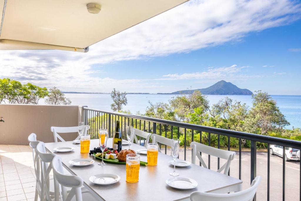 une table sur un balcon avec vue sur l'océan dans l'établissement Albacore 6, à Nelson Bay