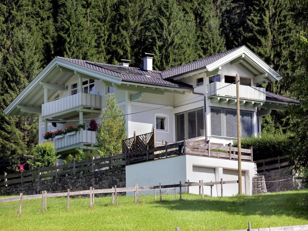 a white house on a hill with trees at Appartement Schwab in Hopfgarten im Brixental
