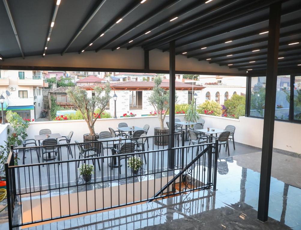 a patio with chairs and tables on a balcony at Vila Franko in Berat