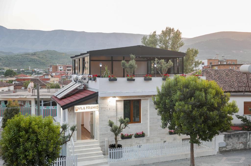 a white house with plants on the top of it at Vila Franko in Berat