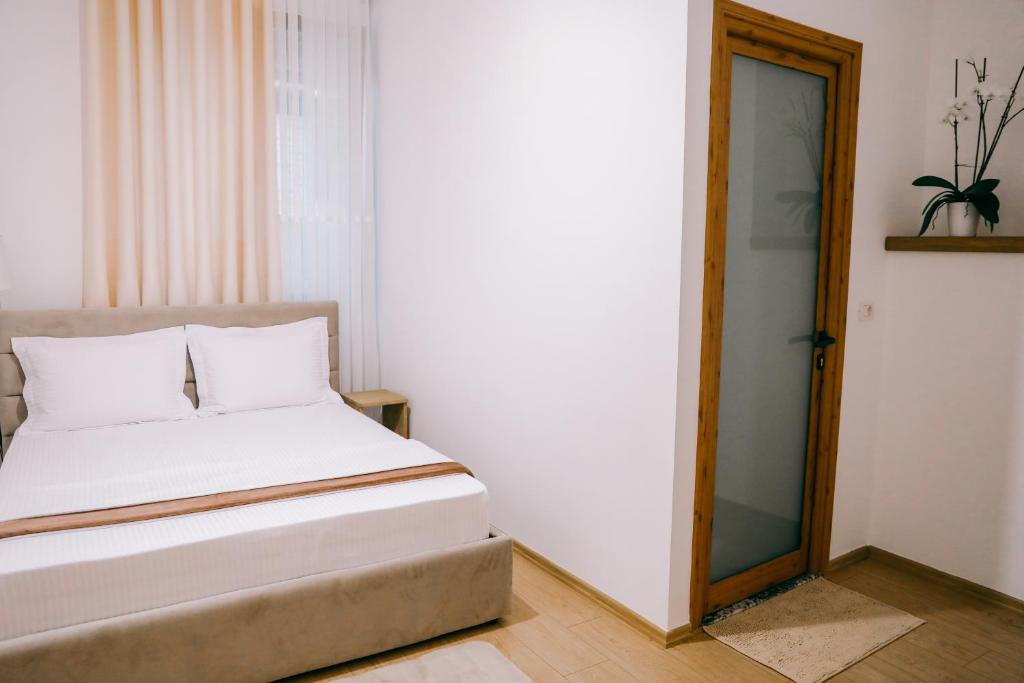 a bedroom with a bed and a glass door at Vila Franko in Berat