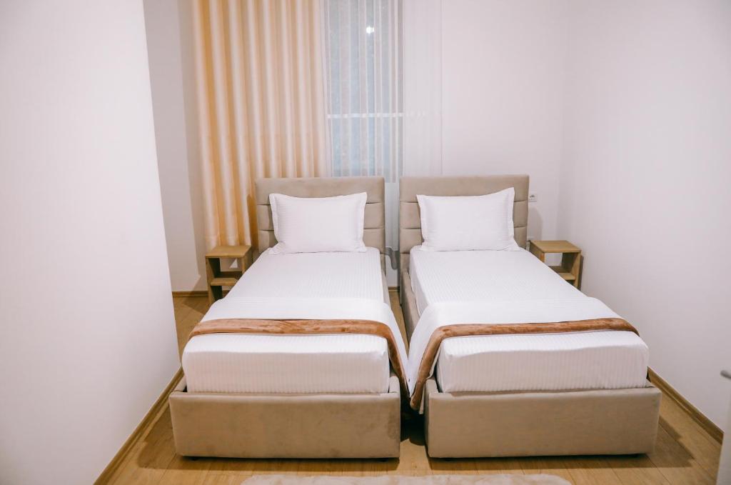 two beds sitting next to each other in a room at Vila Franko in Berat