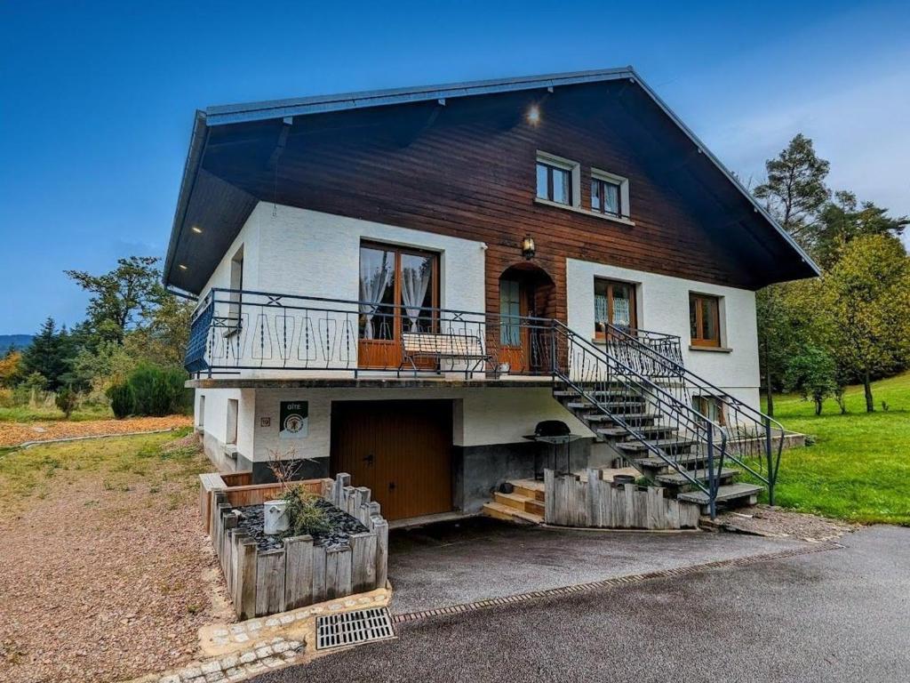 a house with a black roof and a garage at Maison spacieuse près de Gérardmer - 4 pers, ski, randos, lac, bébé ok - FR-1-589-374 in Vagney