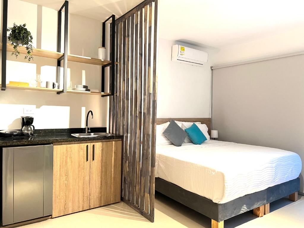 a small bedroom with a bed and a sink at HOTEL 9.5 SAN FERNANDO in Cali