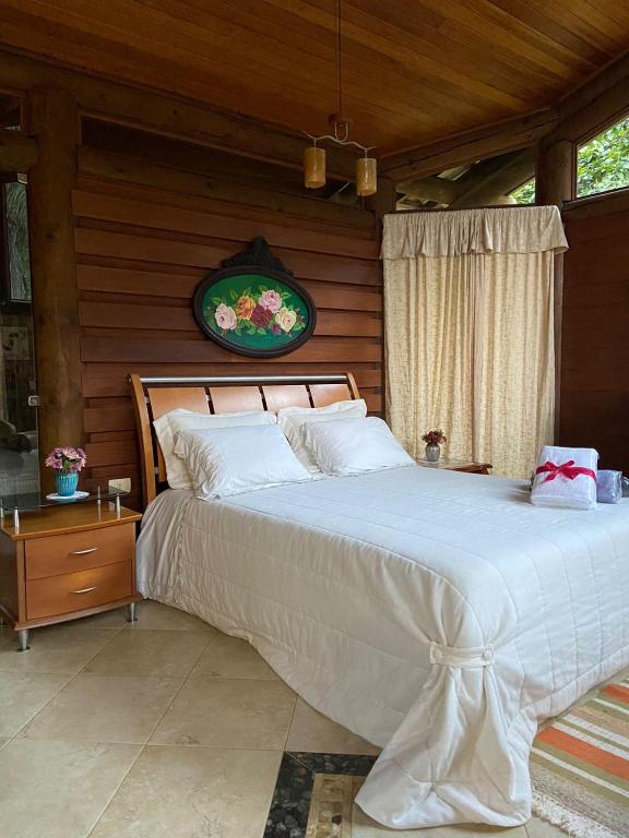 une chambre avec un grand lit dans une pièce en bois dans l'établissement Pousada Rocamadour, à Marechal Floriano