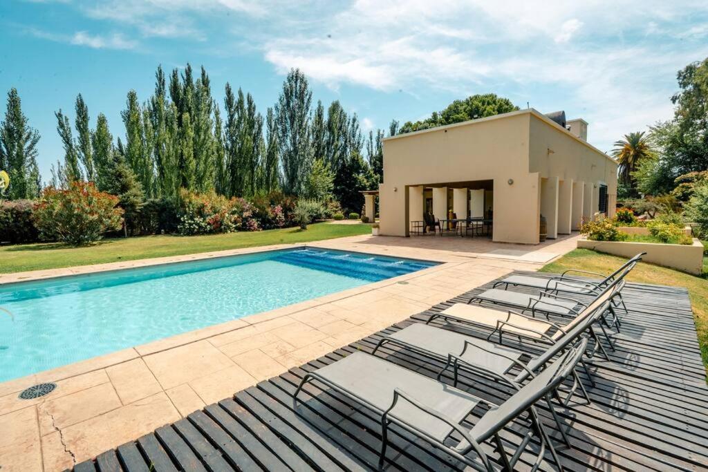 eine Villa mit einem Pool und Liegestühlen in der Unterkunft Fabuloso descanso en Mendoza, Pileta, Zona Bodegas in Lunlunta