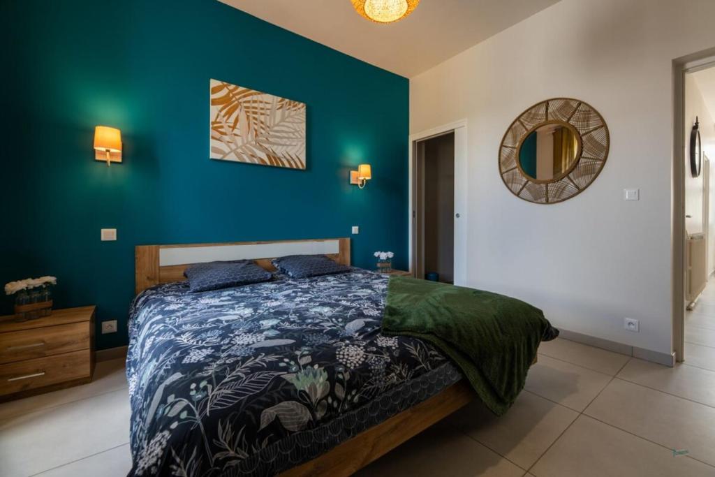 une chambre avec un lit et un mur bleu dans l'établissement Maison en bord de Creuse - 2min d'Argenton, à Le Pêchereau