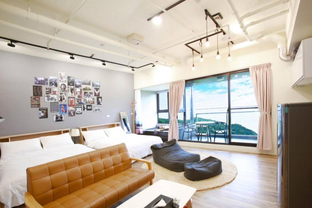 a bedroom with a bed and a couch at 光嶼海溫泉海景無邊際泳池豪華套房 in Hsin-hsing