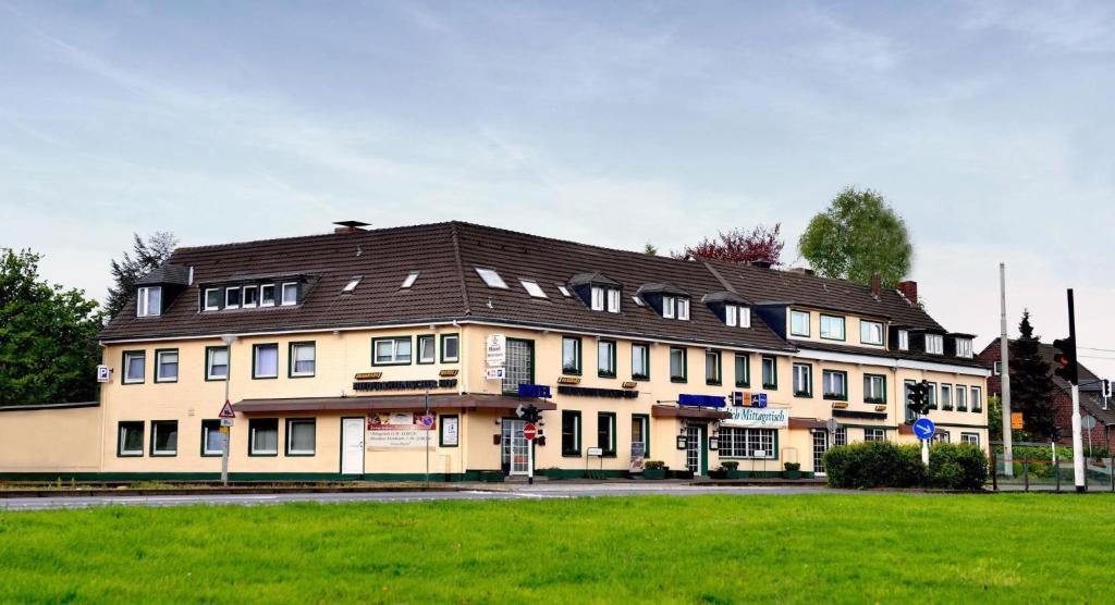 a large tan building with a black roof at Hotel Celina Niederrheinischer Hof in Krefeld