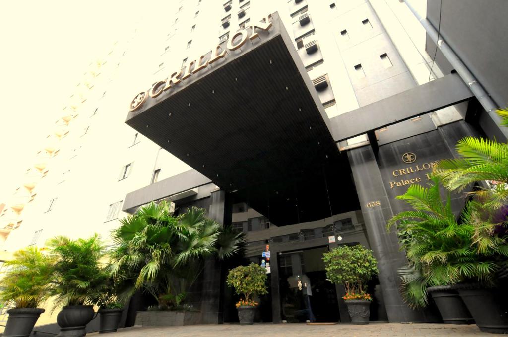 un bâtiment avec des palmiers en face de celui-ci dans l'établissement Crillon Palace Hotel, à Londrina