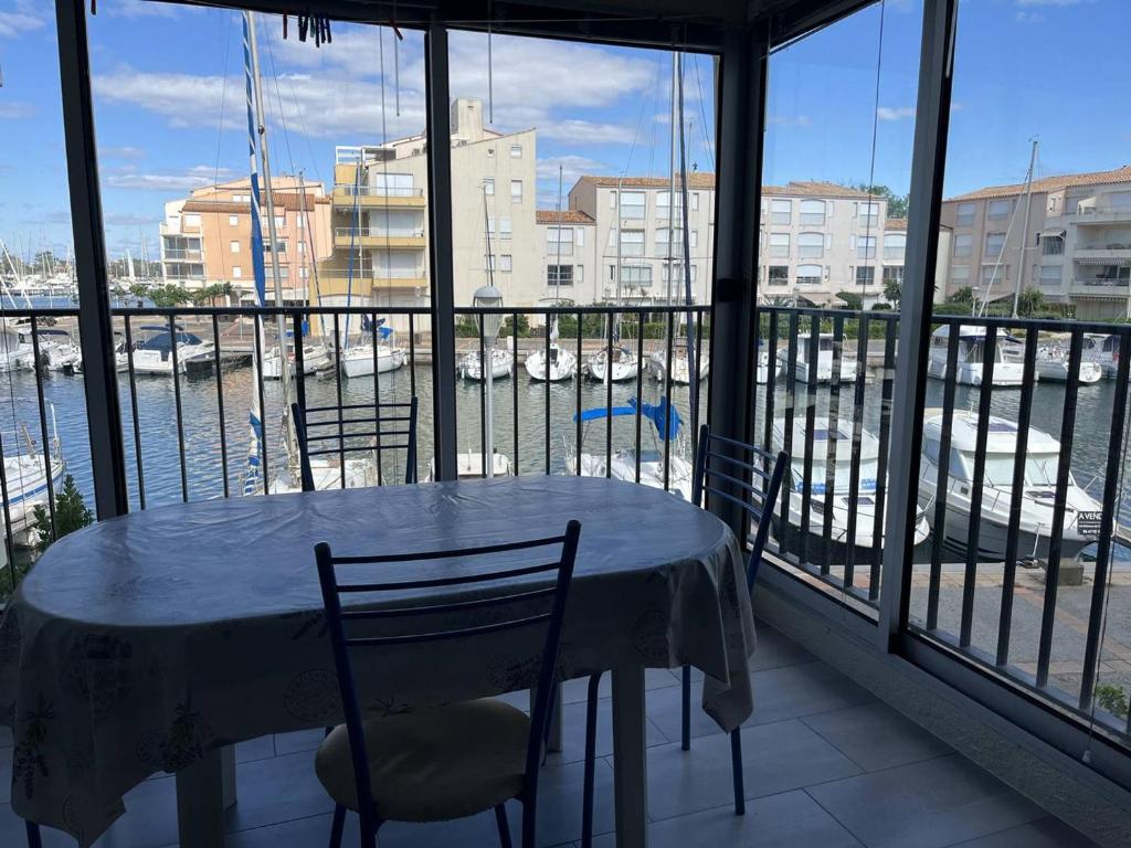 d'une table et de chaises sur un balcon avec vue sur le port. dans l'établissement Appartement T2 au Cap d'Agde - 6 pers, Parking privé, Proche plage et commerces - FR-1-749-70, au Cap d'Agde