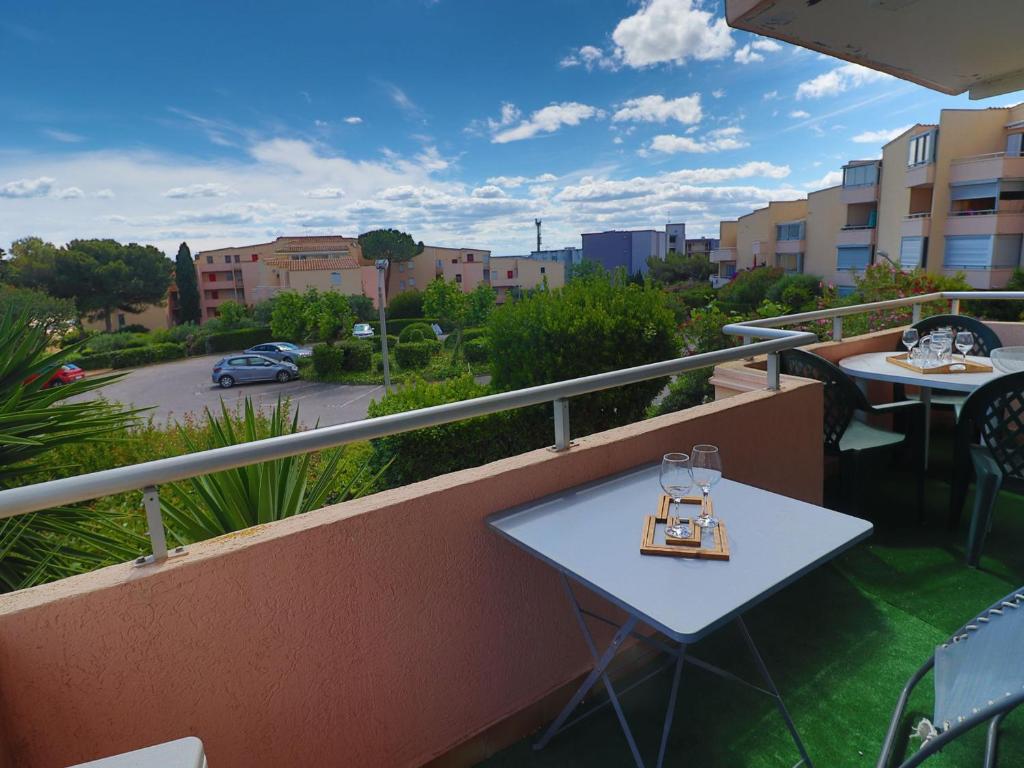 d'une petite table sur un balcon avec vue sur la rue. dans l'établissement Confortable T3 avec PK privé, climatisation et accès direct à la plage - FR-1-472-201, à Sète