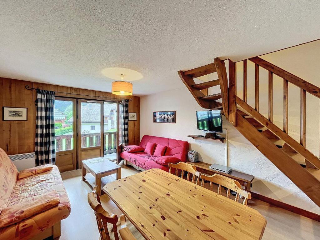 - un salon avec un canapé rouge et un escalier dans l'établissement Chalet à Chamonix, 54m², 3 chambres, 6 personnes - 16 Clos des Outannes, 74400 Chamonix-Mont-Blanc - FR-1-507-79, à Chamonix-Mont-Blanc