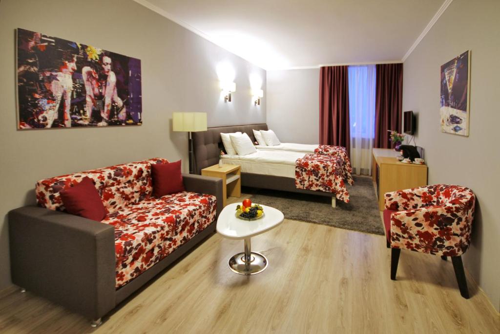 a hotel room with a couch and a bed at City Park Hotel in Chişinău