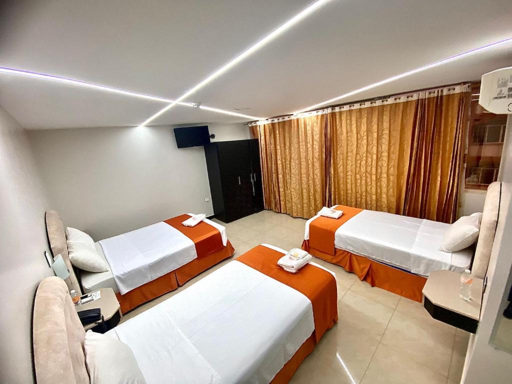 马查拉BRITNEY HOTEL Machala的一间医院房间,设有三张床和窗户