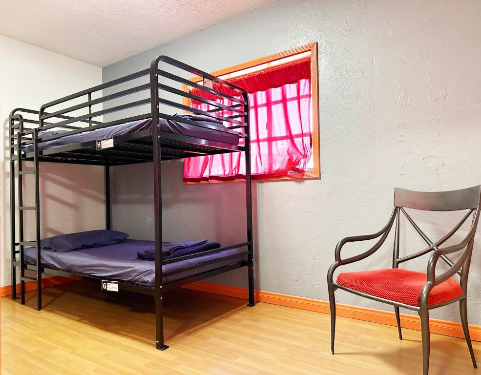 a bedroom with a bunk bed with a chair and a bunk bedutenewayeway at Sin City Hostel in Las Vegas