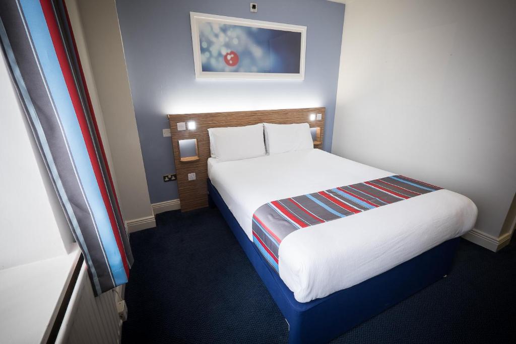 Travelodge Dublin City Rathmines في دبلن: غرفة فندق بسرير في غرفة
