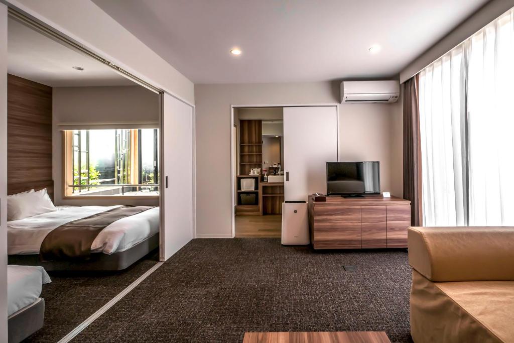 a hotel room with a bed and a television at HOTEL R9 Kujukuri "ex Casual Resort COFF Ichinomiya" in Ichinomiya