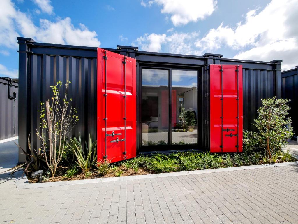 a black and red house with red doors at HOTEL R9 Kujukuri "ex Casual Resort COFF Ichinomiya" in Ichinomiya