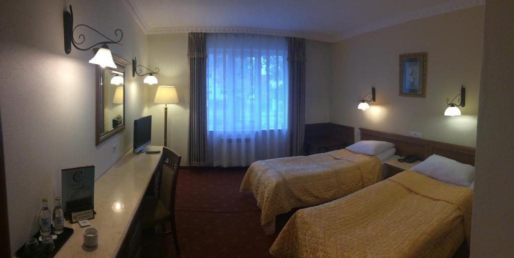 pokój hotelowy z dwoma łóżkami i oknem w obiekcie Hotel Colosseum w mieście Olecko