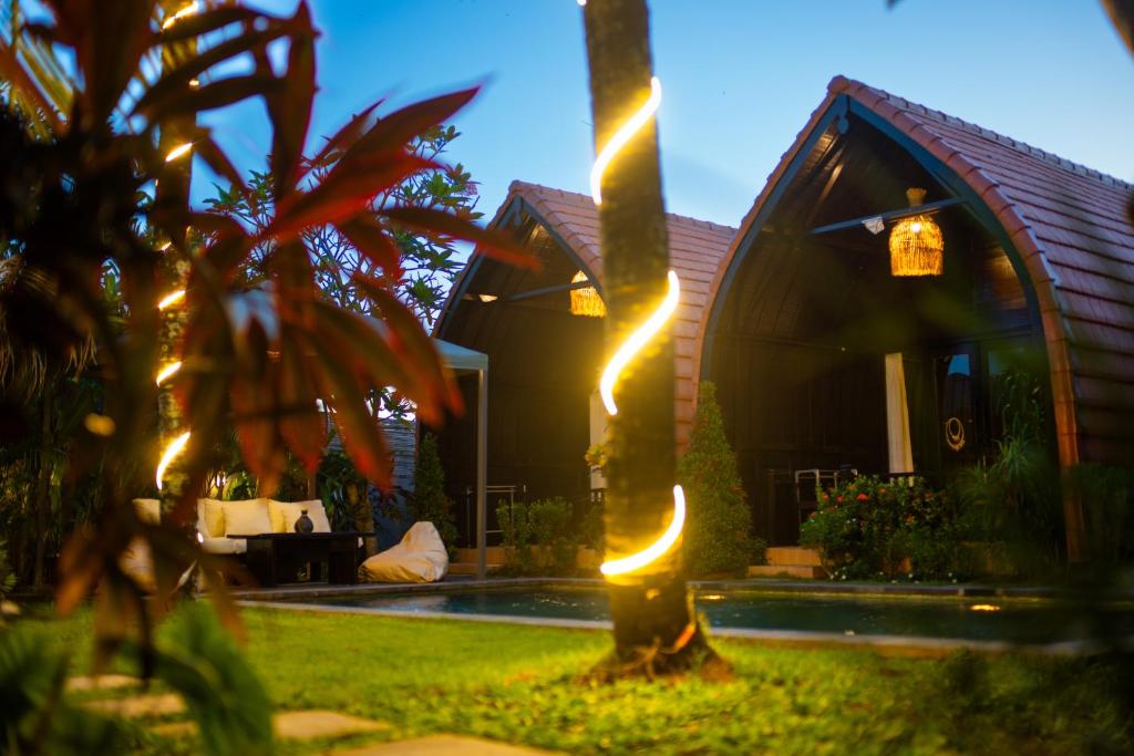 ein Haus mit Lichtern auf einer Palme in der Unterkunft Villa Lumbung Sari - Tropical Balinese Experience in Canggu
