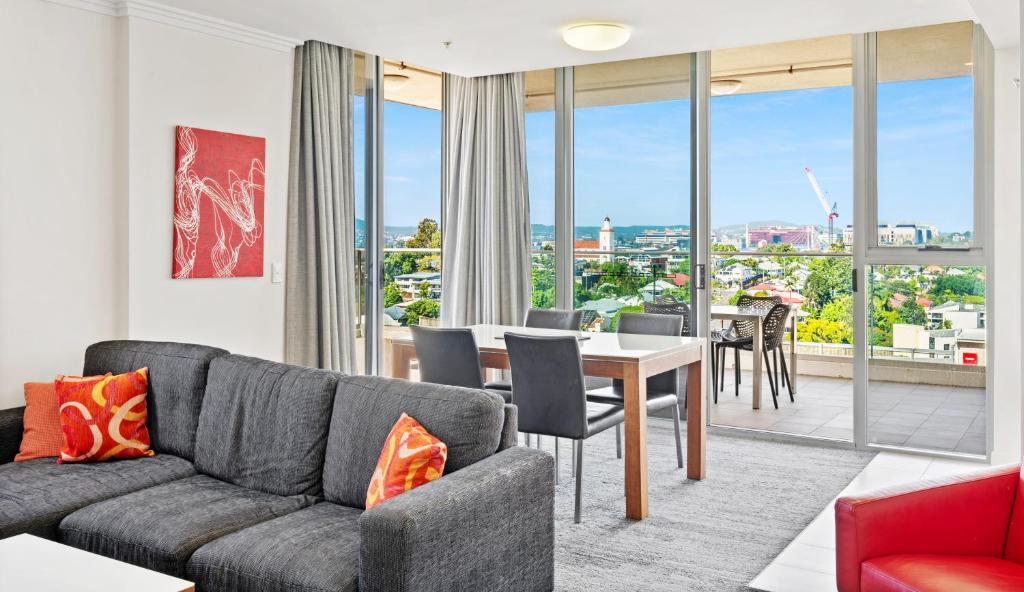a living room with a couch and a table at Hotel Diana South Brisbane in Brisbane