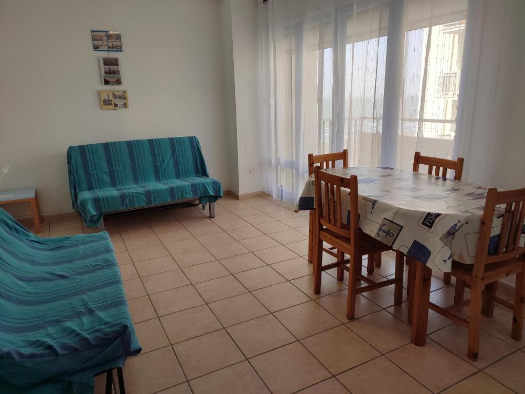 une pièce avec une table, des chaises et un canapé dans l'établissement T1 dans immeuble sur plage, au Grau-du-Roi