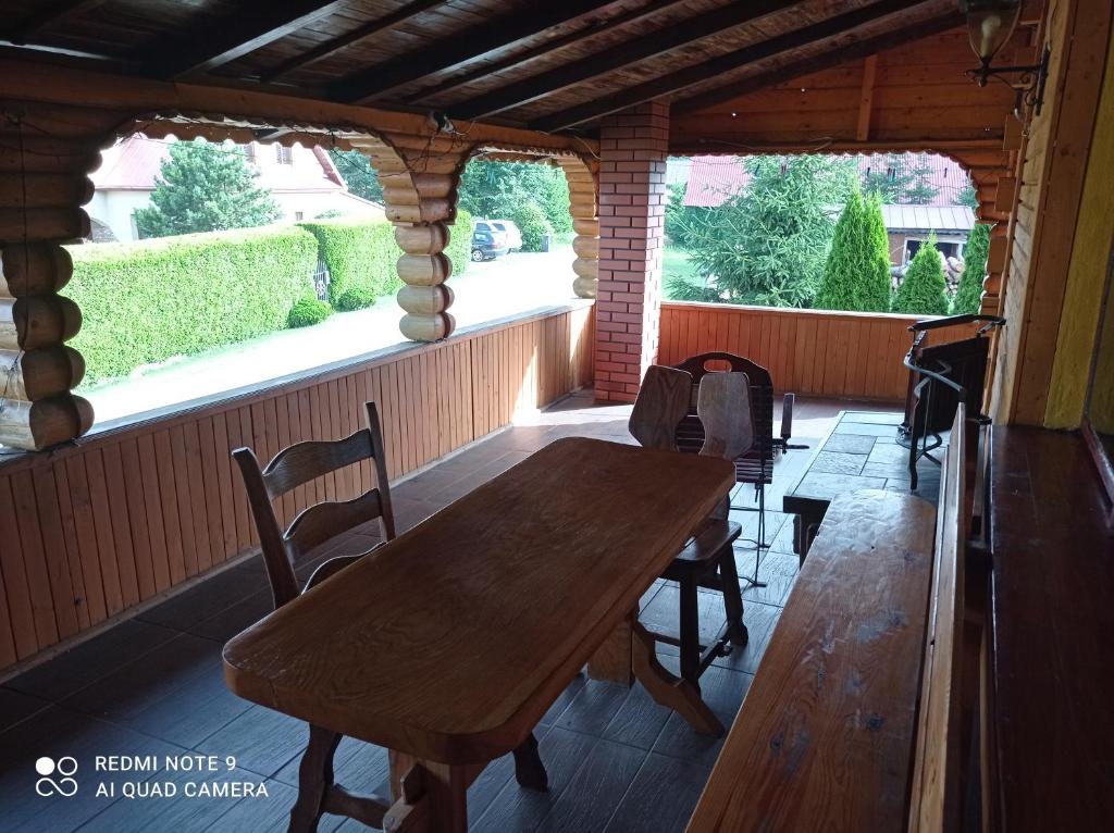 a dining room with a wooden table and two windows at Pokoje u Janeczki in Jałowo