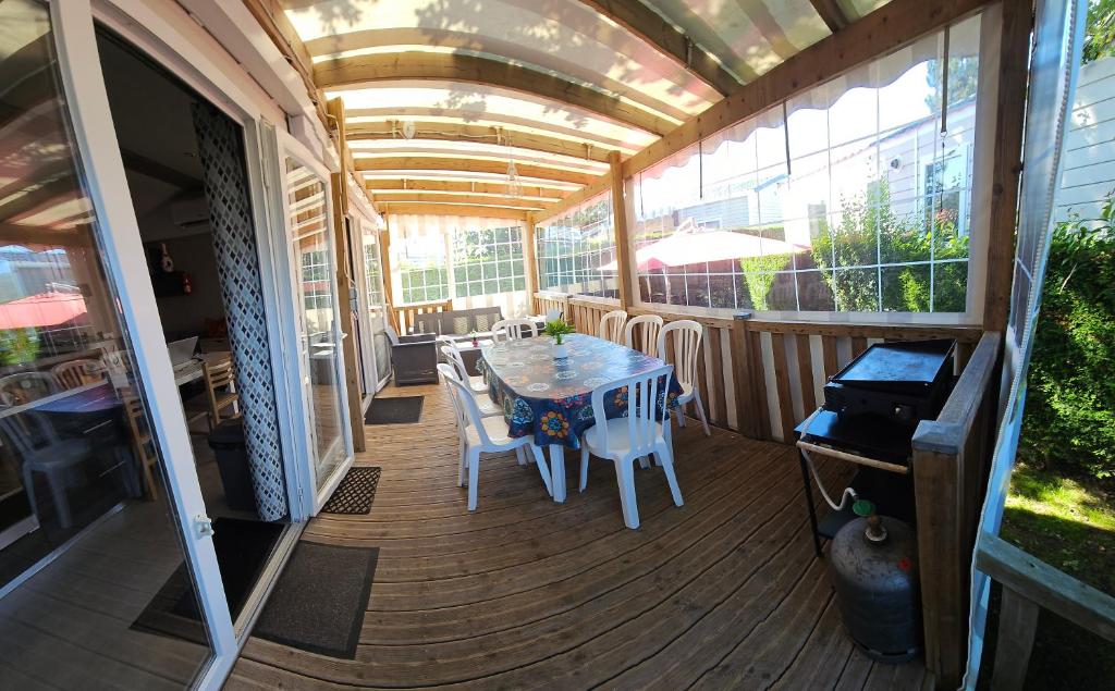 un patio avec une table et des chaises sur une terrasse dans l'établissement mobilhome 741 Les Charmettes,3ch,2sdb,lave linge,lave vaisselle,clim,2wc, aux Mathes