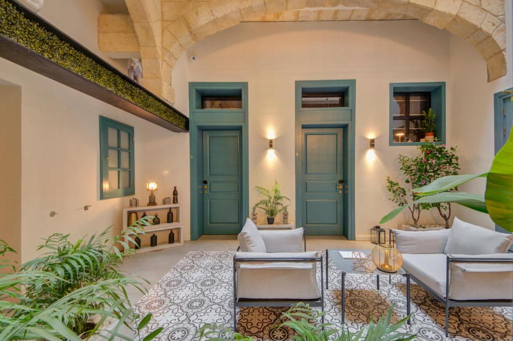 an indoor patio with blue doors and plants at 23 Boutique Hotel in Il-Furjana