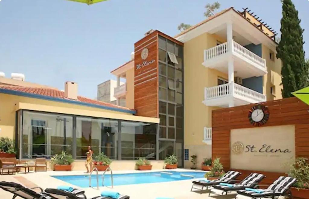 a hotel with a swimming pool in front of a building at St Elena Boutique Residence in Larnaka