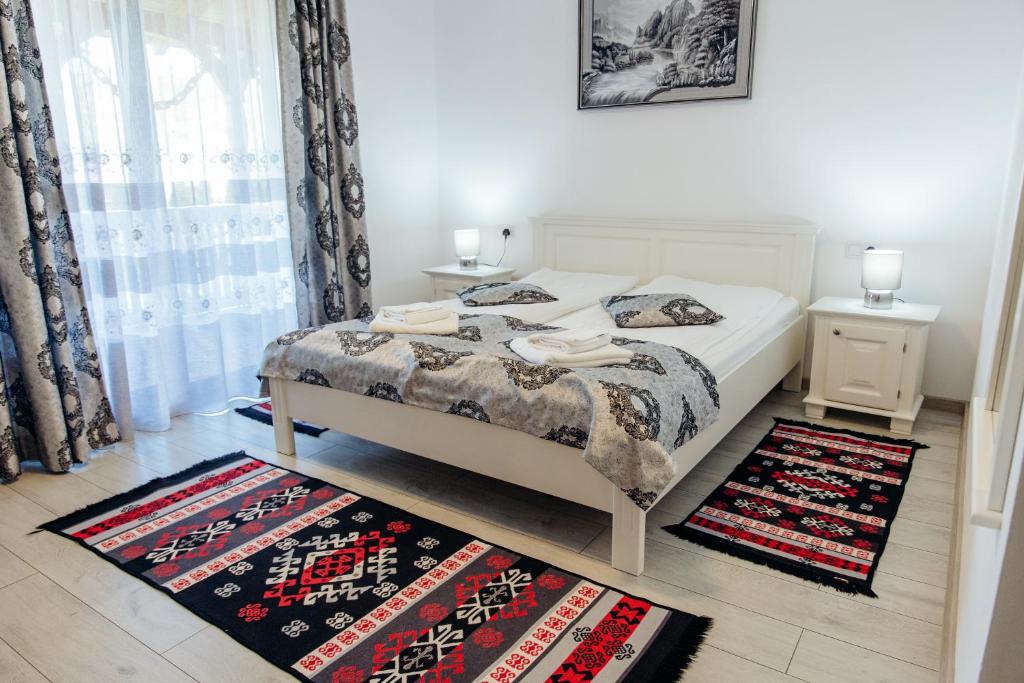 a bedroom with a bed and two rugs on the floor at Casa Alexandru – Locul în care te simți acasă in Vişeu de Jos