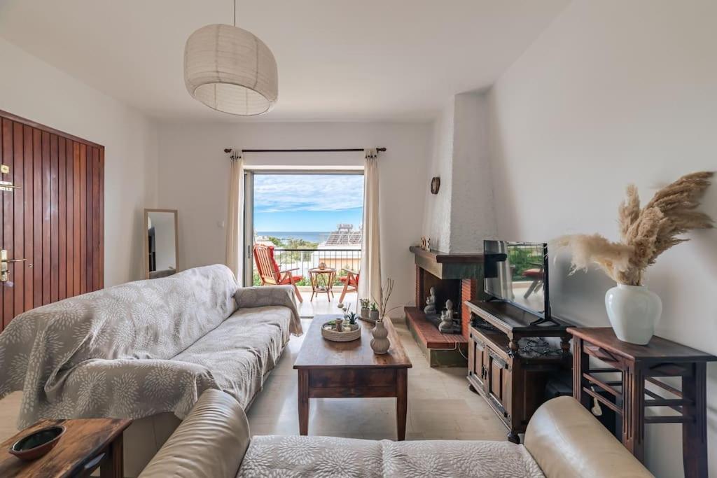 a living room with a couch and a television at Seaside escape apartment in Saronida