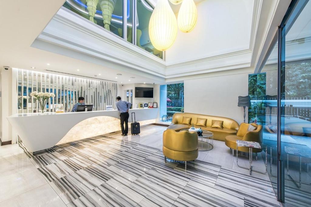 A tall, brightly lit lobby with a curved reception desk and lounge seating.