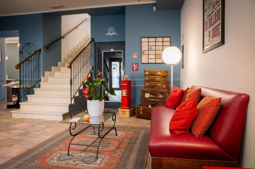 a living room with a red couch and a table at Hotel Ligure in Cuneo