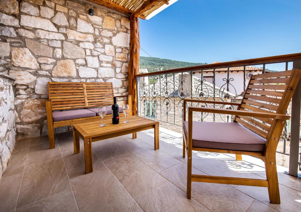 a patio with two chairs and a table on a balcony at Theros Easy Living in Theologos