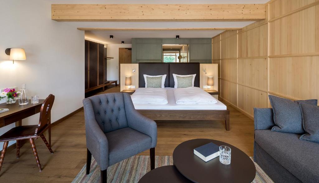 a hotel room with a bed and a table and chairs at Gutshofhotel Winkler Bräu in Lengenfeld