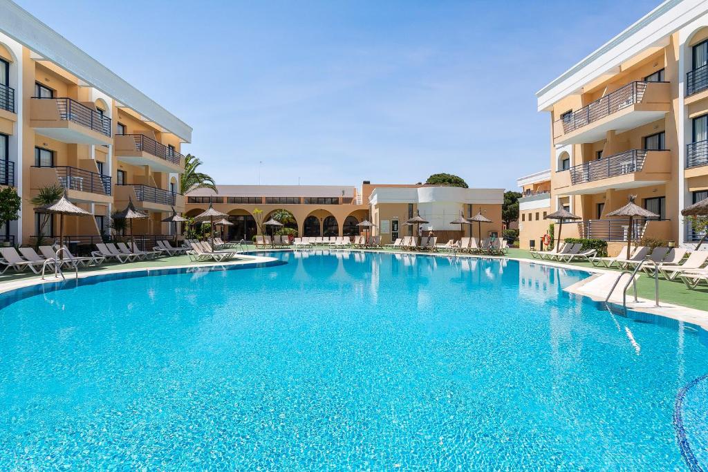 a large swimming pool in front of a building at Sol Sancti Petri Aparthotel in Chiclana de la Frontera