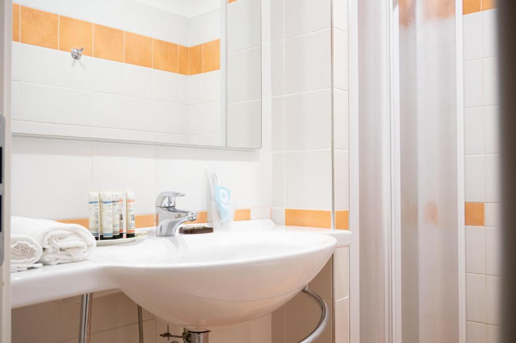 łazienka z umywalką i lustrem w obiekcie Hotel Ligure w mieście Cuneo