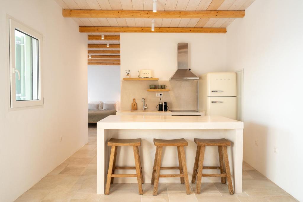 a kitchen with a counter with two stools and a stove at Sea and Sun ll in Ios Chora